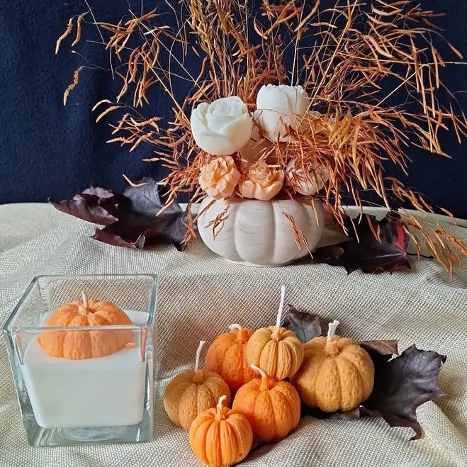 Ensemble d'automne avec bougies citrouilles et bouquet dans pot citrouille