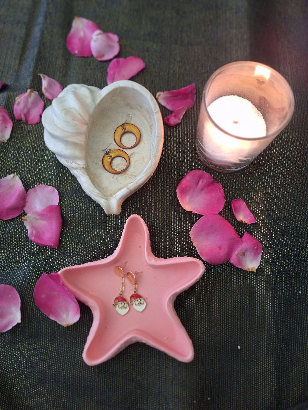 2 coupelles en resine ecologique jesmonite contenant une paire de boucles d'oreilles. Entourees de petales de roses fraichement tombes de leur fleur